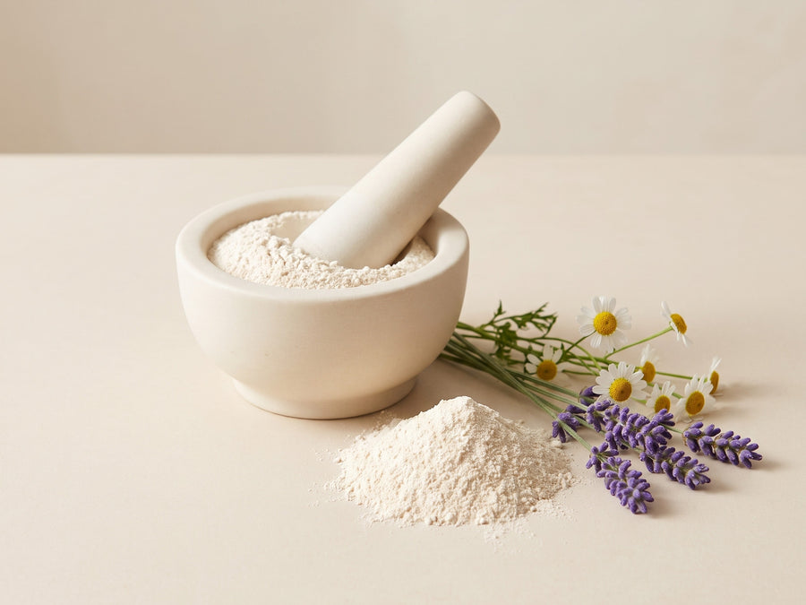 Plant-based powder in a stone mortar with lavender and chamomile